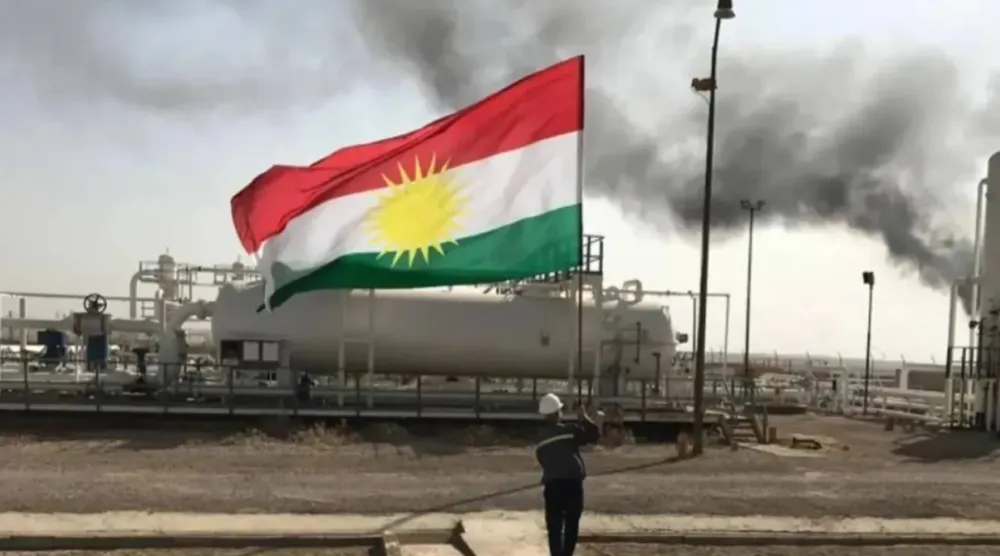 A staff at an oilfield holds the flag of Kurdistan. (X)
