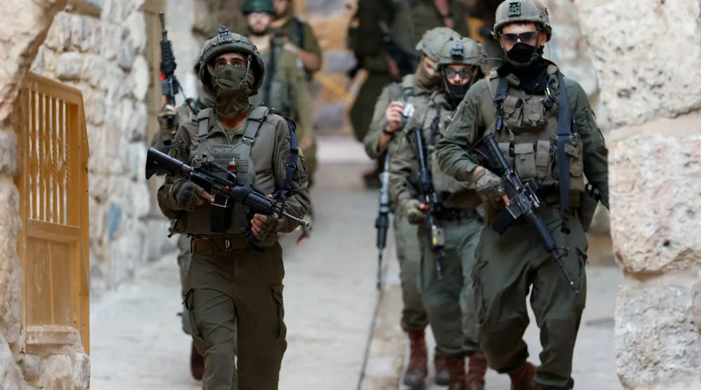 جنود إسرائيليون يحملون أسلحة في الضفة الغربية (رويترز)