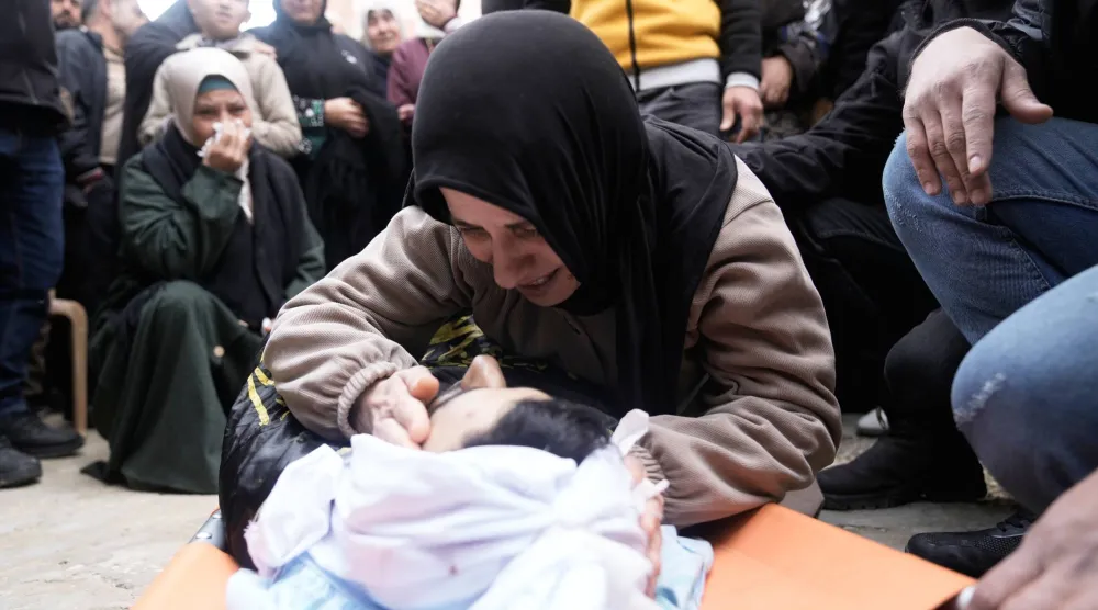 والدة أحمد زيود خلال تشييع جثمانه خلال جنازته قرب جنين في الضفة الغربية اليوم (أ.ب)