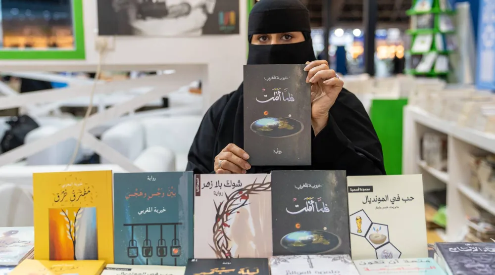الكاتبة خيرية المغربي مع إصداراتها الأدبية (الشرق الأوسط)