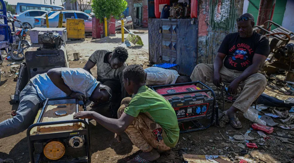 سودانيون يعملون على إصلاح مولد كهربائي بورشة عمل بالمنطقة الصناعية في بورتسودان يوم 19 ديسمبر الحالي (أ.ف.ب)