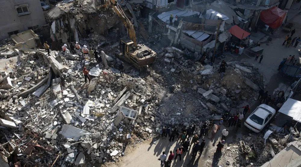 عناصر من الدفاع المدني الفلسطيني يزيلون ركام منزل في خان يونس خلال عمليات البحث عن جثامين ضحايا الحرب على غزة يوم السبت (إ.ب.أ)