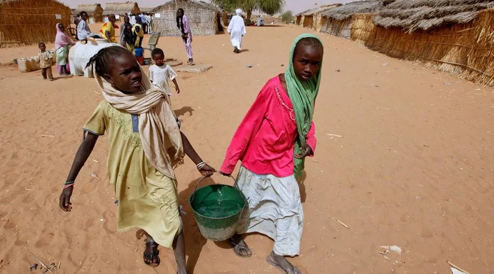 Sudanese refugee girls carry water supplies near a polling station in the refugee camp of Zamzam, on the outskirts of el-Fasher, Darfur, Sudan, on April 13, 2010. (AP) 