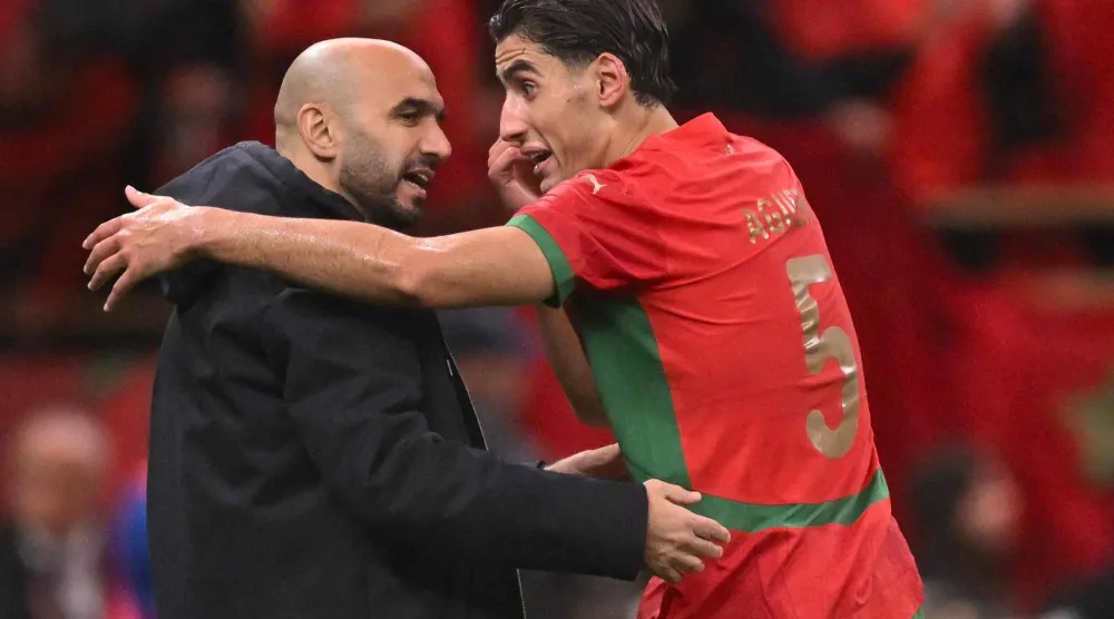 وليد الركراكي مدرب المغرب مع لاعبه نايف أغرد (أ.ف.ب)