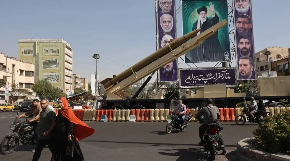 صاروخ باليستي إيراني يُعرَض بجانب لافتة تحمل صورة المرشد علي خامنئي وقادة من «الحرس الثوري» قُتلوا في هجمات إسرائيلية في أحد شوارع طهران (أرشيفية - رويترز)