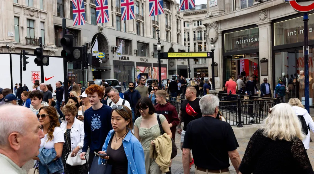 أشخاص ومتسوقون يعبرون مفترق الطرق في «أكسفورد سيرك» بلندن (رويترز)