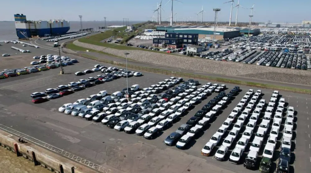 صورة جوية تُظهر سيارات مجموعة «فولكسفاغن» متجهة نحو شحنها على متن سفينة للتصدير إلى الولايات المتحدة بميناء إمدن (رويترز)