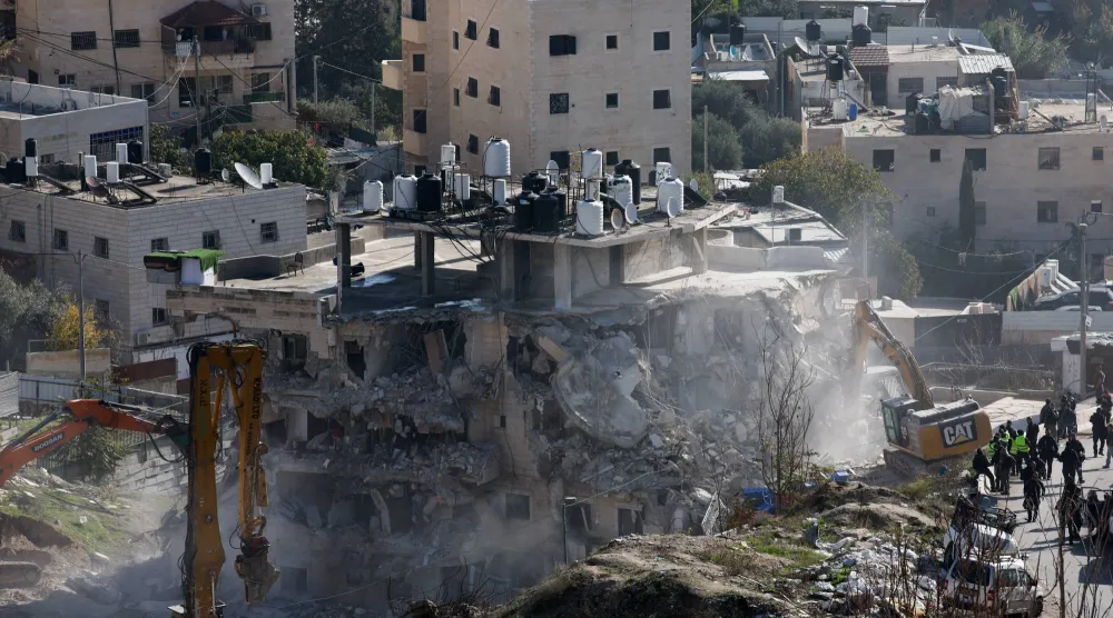 الآليات الإسرائيلية تقوم بهدم المبنى السكني في القدس الشرقية (رويترز)