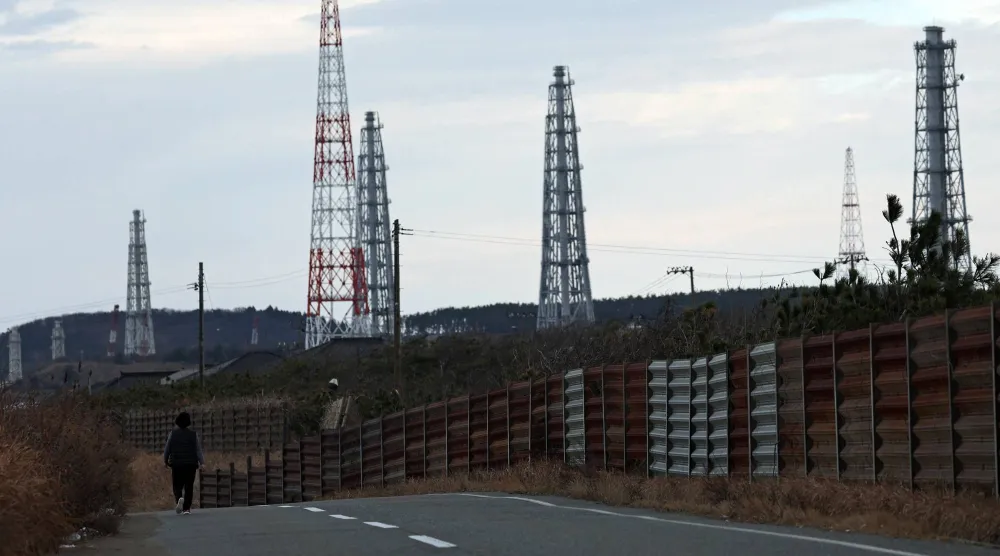 رجل يمر في طريق قرب محطة كاشيوازاكي - كاريوا الكهربائية النووية شمال غربي العاصمة اليابانية طوكيو (رويترز)