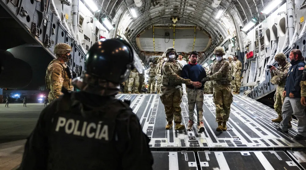 أفراد من الجيش الأميركي يرافقون أعضاءً مزعومين في عصابة ترين دي أراغوا الفنزويلية وعصابة إم إس-13 رحّلتهم الحكومة الأميركية إلى مركز احتجاز في السلفادور (رويترز)