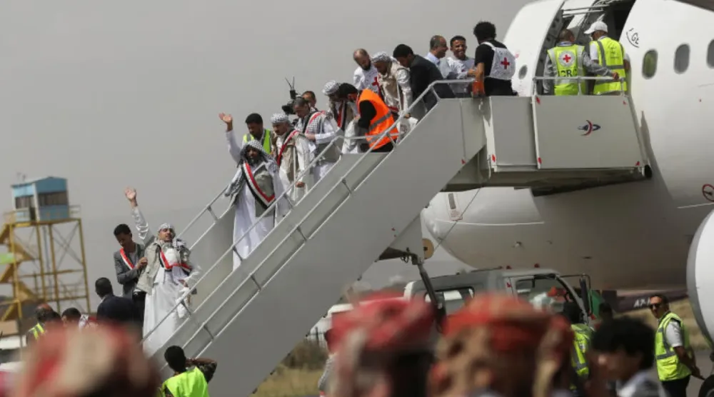 أسرى يلوِّحون بأيديهم لدى وصولهم إلى مطار صنعاء في عملية تبادل سابقة (أرشيفية- رويترز)