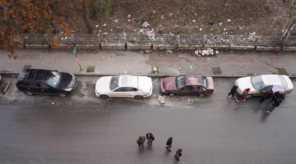 سكان بعض أحياء مدينة حلب يتفقدون سيارات متضررة الثلاثاء عقب موجة هجمات في اليوم السابق (رويترز)