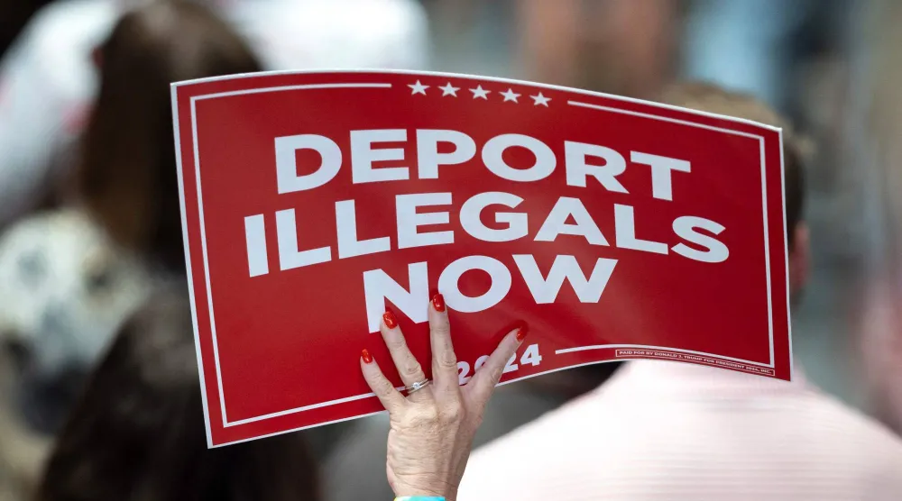 أحد المؤيدين لترمب يحمل لافتة مكتوباً عليها «ترحيل المهاجرين غير الشرعيين الآن» خلال تجمع انتخابي العام الماضي (أ.ف.ب)