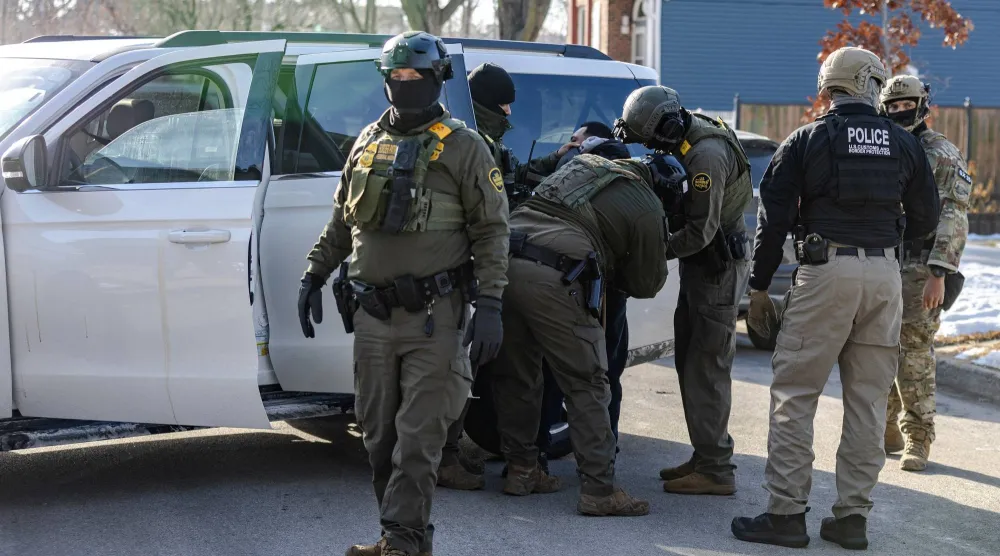 عملاء فيدراليون أميركيون يحتجزون رجلاً خلال مداهمة متعلقة بالهجرة في مدينة شيكاغو (رويترز)