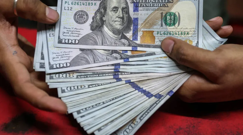 يعرض أحد مكاتب الصرافة في مومباي أوراق نقدية من فئة 100 دولار أميركي (إ.ب.أ)