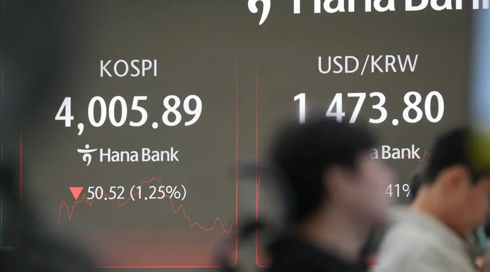 متعاملون قرب شاشات تعرض مؤشر «كوسبي» وسعر صرف الدولار مقابل الوون ببنك «هانا» في سيول بكوريا الجنوبية (أ.ب)