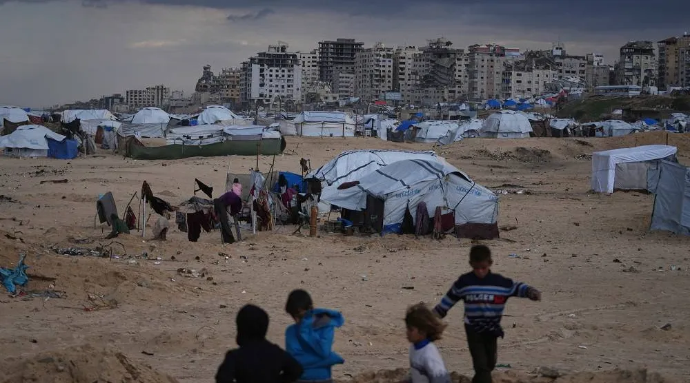 Palestinian children play next to tents in a makeshift camp for displaced people set up on the beach in Gaza City, Tuesday, Dec. 16, 2025. (AP)
