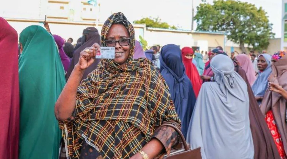 مواطنة صومالية ترفع بطاقتها الانتخابية خلال تجمع لدعم إجراء الانتخابات المحلية (وكالة الأنباء الصومالية)
