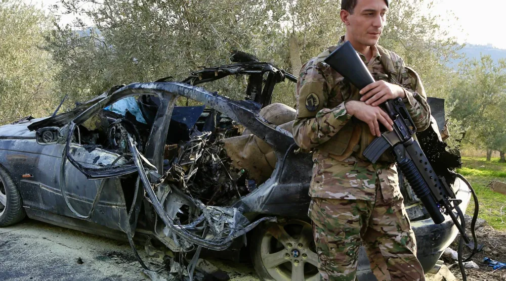 عنصر من الجيش اللبناني يقف قرب سيارة مستهدفة في بلدة عقتنيت بقضاء الزهراني استهدفتها غارة إسرائيلية الثلاثاء (إ.ب.أ)