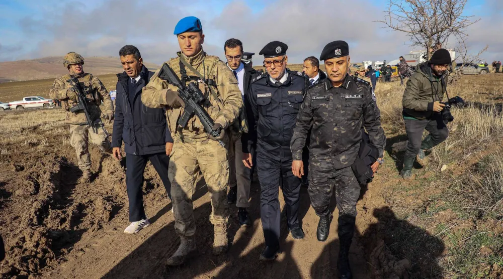 عناصر الوفد الليبي خلال وصولهم إلى مكان تحطم الطائرة المنكوبة (أ.ف.ب)