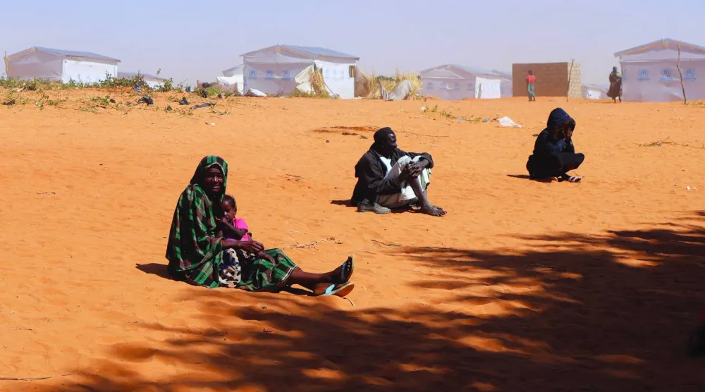 لاجئون سودانيون من دارفور يجلسون على الأرض أثناء عاصفة رملية في مخيم طولوم على مشارف بلدة إيريبا شرق تشاد - ٣٠ نوفمبر (رويترز)