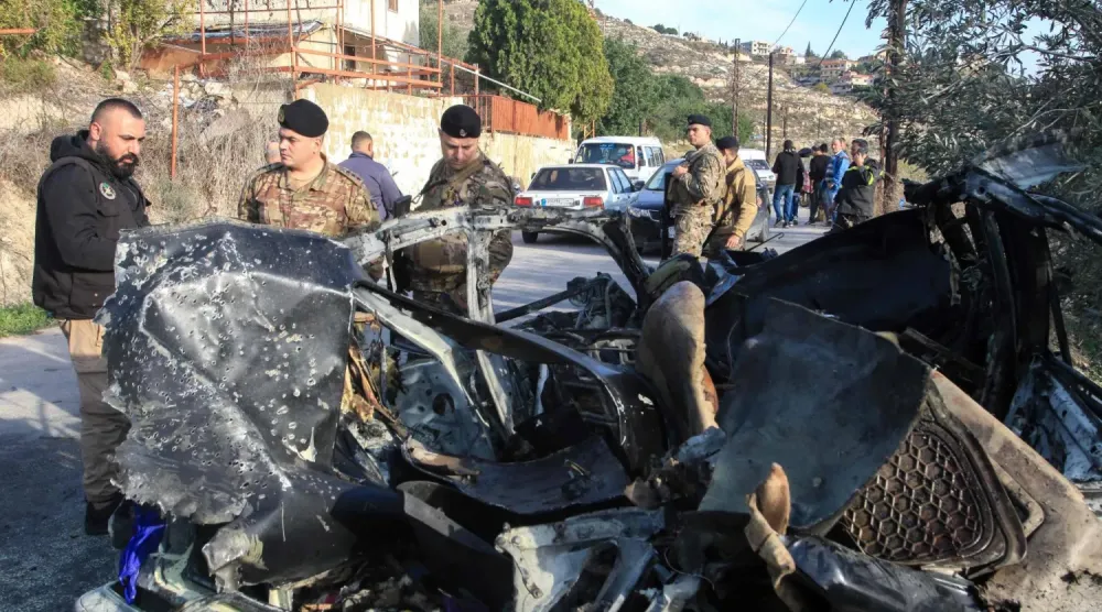 Lübnan askerleri, İsrail'in güney Lübnan'a düzenlediği baskında hedef alınan bir aracın enkazının yanında, (AFP)