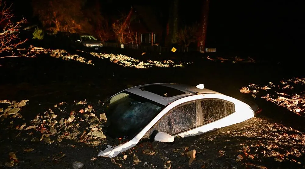  A car sits buried in mud after flooding Wednesday, Dec. 24, 2025, in Wrightwood, Calif. (AP) 