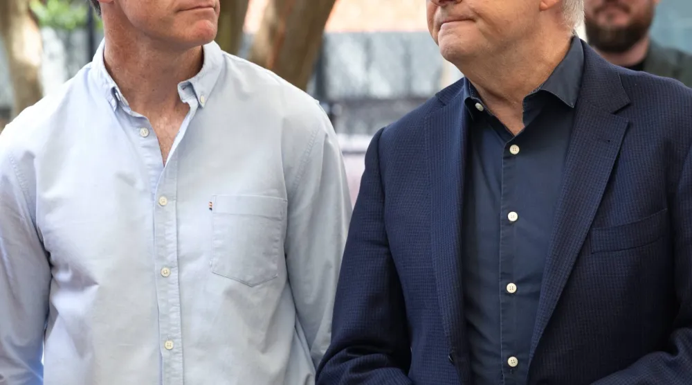 رئيس وزراء ولاية نيو ساوث ويلز كريس مينز (يسار) ونظيره الأسترالي أنتوني ألبانيزي (يمين) يحضران غداءً بمناسبة عيد الميلاد استضافته مؤسسة القس بيل كروز بسيدني الخميس (إ.ب.أ)