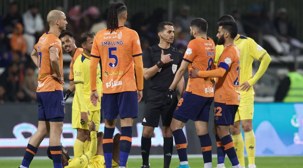 الحكم الزهراني في نقاش مع لاعبي الفريقين بعد إحدى الحالات (تصوير: نايف العتيبي)