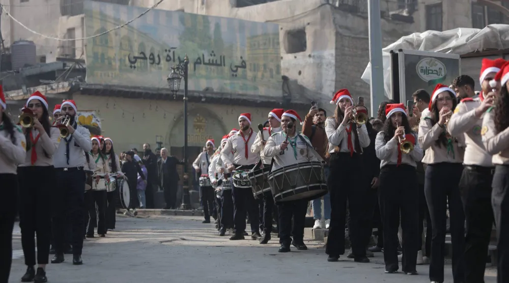 أعضاء في الكشافة السورية يعزفون في شوارع مدينة دمشق القديمة احتفالاً بعيد الميلاد أمس (أ.ف.ب)

