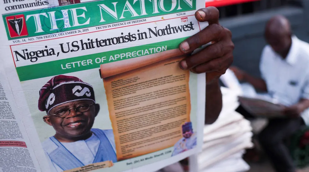 يقرأ الناس الصحف التي تنشر أخباراً عن الغارات الجوية الأميركية على مقاتلي تنظيم «داعش» - لاغوس - نيجيريا - 26 ديسمبر 2025 (رويترز)