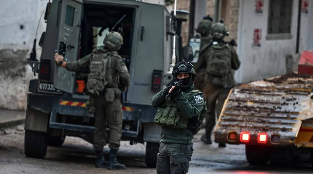 Israeli security forces secure a street as they leave the Palestinian village of Bizariya, in the occupied West Bank, where Israeli authorities demolished the house of a Palestinian man killed in July after he and another man reportedly killed an Israeli settler on the same day, on December 24, 2025. (AFP)