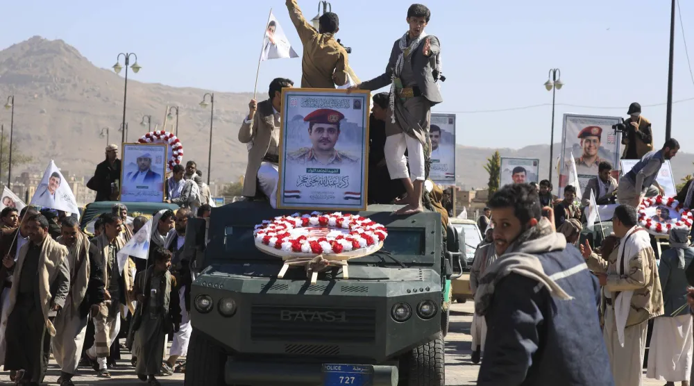 مركبات عسكرية تحمل نعوشاً وصوراً لكبار قادة الحوثيين العسكريين الذين قُتلوا في غارة جوية أميركية (إ.ب.أ)