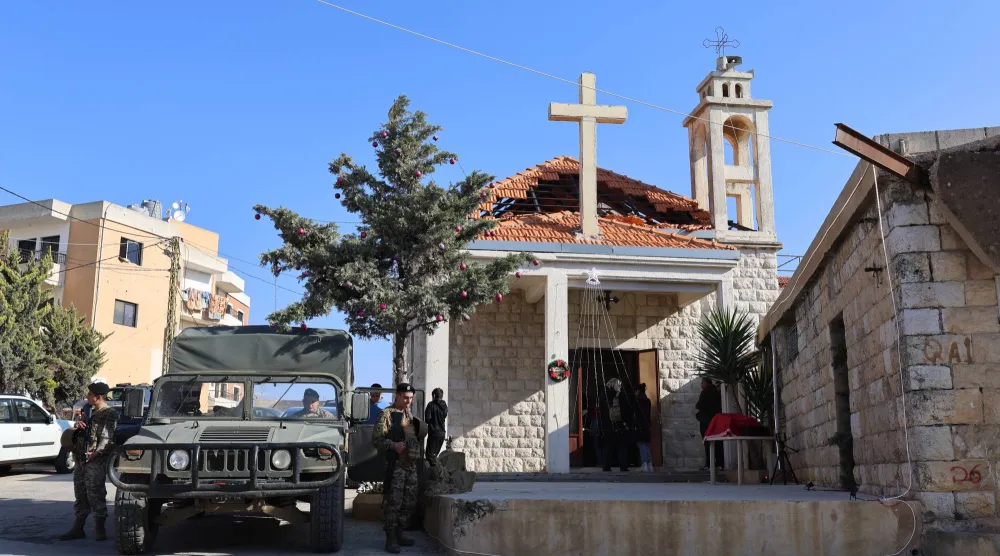 دورية للجيش اللبناني قرب كنيسة متضررة جراء الحرب في بلدة الخيام بجنوب لبنان صباح عيد الميلاد الخميس (إ.ب.أ)