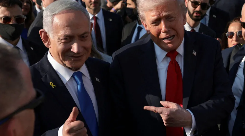 الرئيس الأميركي دونالد ترمب يشير بيده بجانب رئيس الوزراء الإسرائيلي بنيامين نتنياهو في مطار بن غوريون الدولي خلال زيارته إسرائيل 13 أكتوبر 2025 (رويترز)