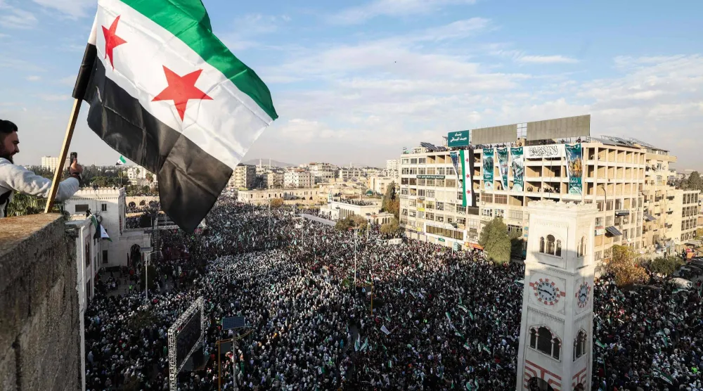 علم سوريا خلال احتفالات مرور عام على سقوط نظام بشار الأسد وسط حماة (أرشيفية - أ.ف.ب)