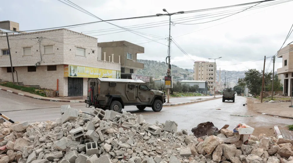 مركبات عسكرية تعمل خلال غارة إسرائيلية على بلدة قباطية قرب جنين (رويترز)