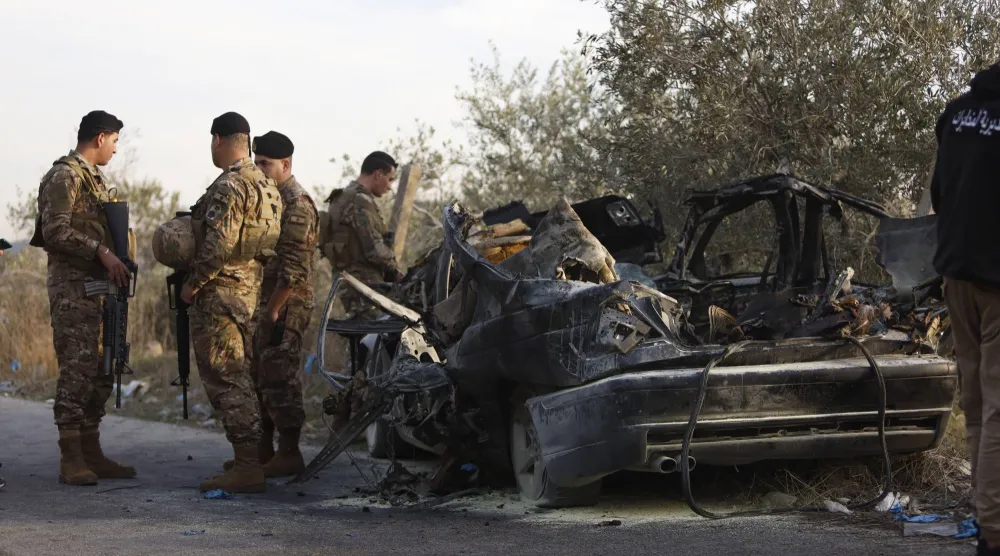 عناصر في الجيش اللبناني يقفون قرب سيارة استهدفتها غارة إسرائيلية في بلدة عقتنيت بجنوب لبنان وأسفرت عن مقتل 3 أشخاص (د.ب.أ)