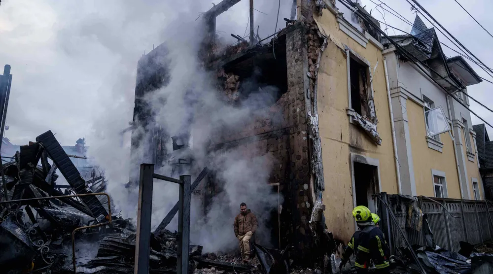 رجل يخرج من منزل دُمّر بعد غارة روسية على كييف (أ.ب)