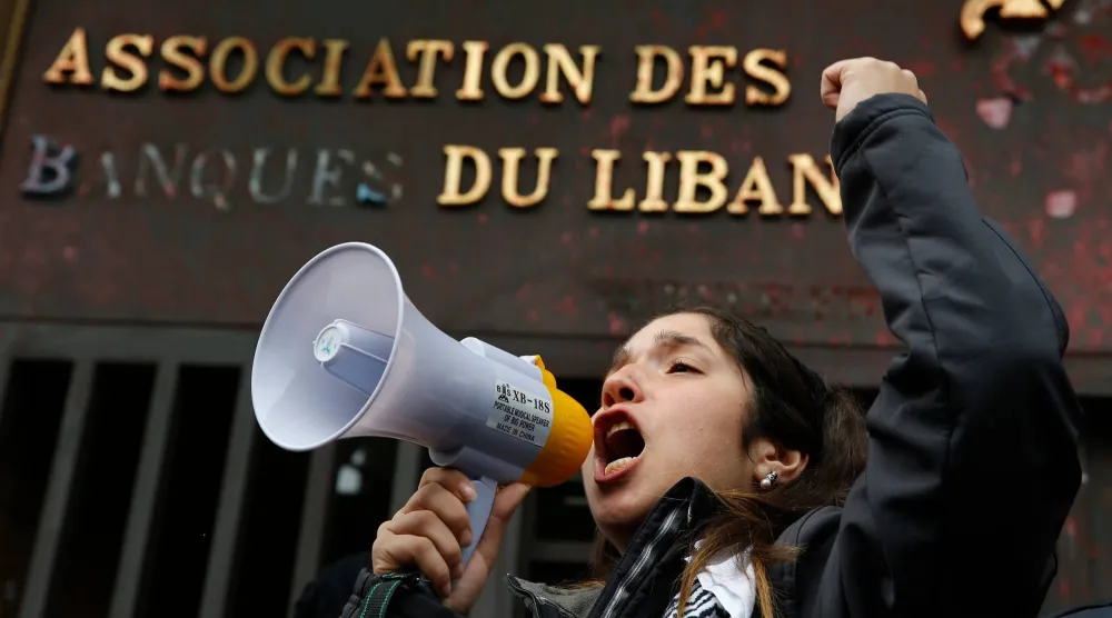 لبنانية تعتصم أمام مبنى «جمعية المصارف» في بيروت بعد الأزمة المعيشية في 2019 (أرشيفية - أ.ب)