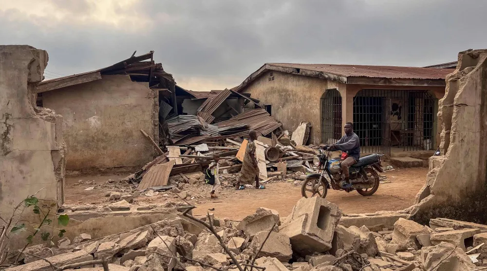 سكان يتفقّدون آثار الضربة الأميركية في قرية أوفا يوم 27 ديسمبر (أ.ف.ب)