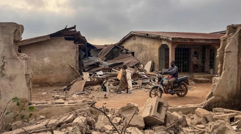 ABD saldırısının ardından Oufa köyünde bölge sakinleri hasarı incelerken 27 Aralık 2025 (AFP)