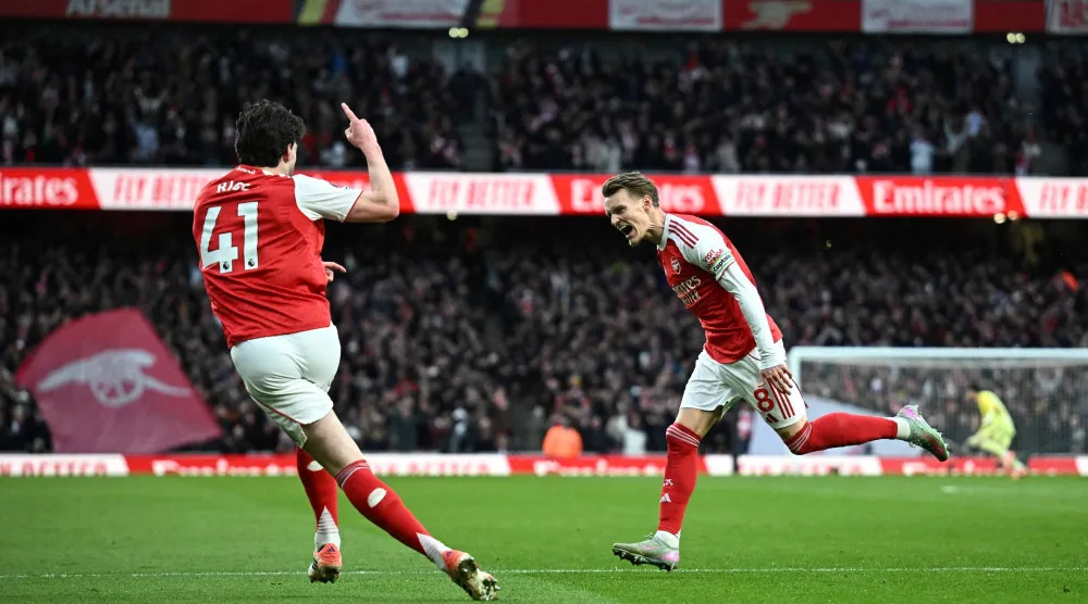 مارتن أوديغارد يحتفل مع ديكلان رايس بهدف آرسنال الأول في برايتون (رويترز)