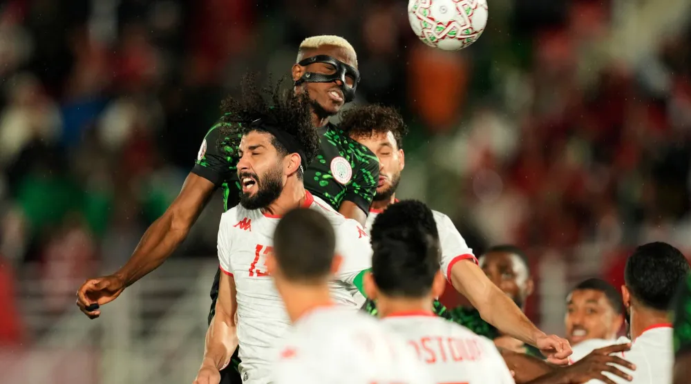 Nigeria's Victor Osimhen, top, wins a header against Tunisia's Ferjani Sassi during the Africa Cup of Nations group C soccer match between Nigeria and Tunisia in Fez, Morocco, Saturday, Dec. 27, 2025. (AP Photo/Mosa'ab Elshamy)