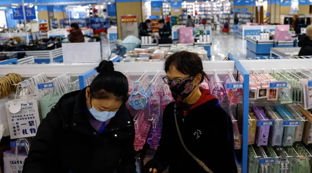 زبائن يتسوقون بمتجر في بكين التي تعتزم تعزيز الطلب المحلي (رويترز)
