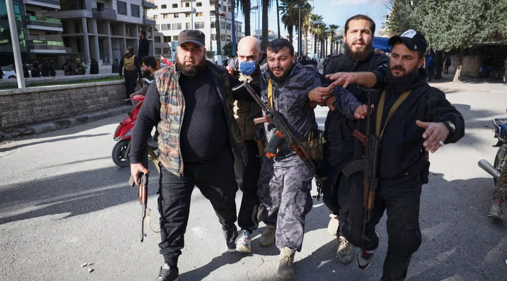 إبعاد ضابط شرطة مصاب عن منطقة الاحتجاجات في اللاذقية (أ.ب)