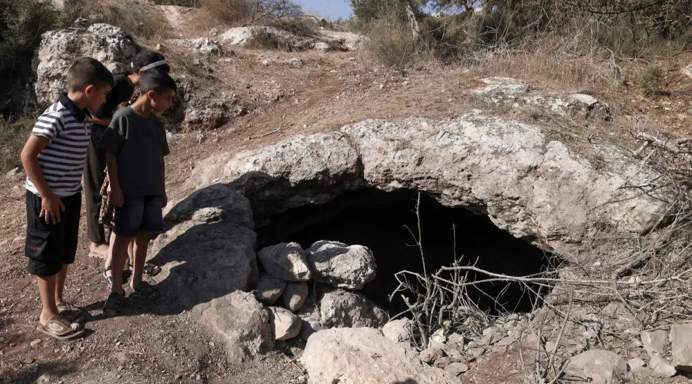 صبية فلسطينيون ينظرون إلى كهف قُتل فيه 3 شبان على يد القوات الإسرائيلية قرب مدينة جنين بالضفة الغربية أكتوبر الماضي (أ.ف.ب)