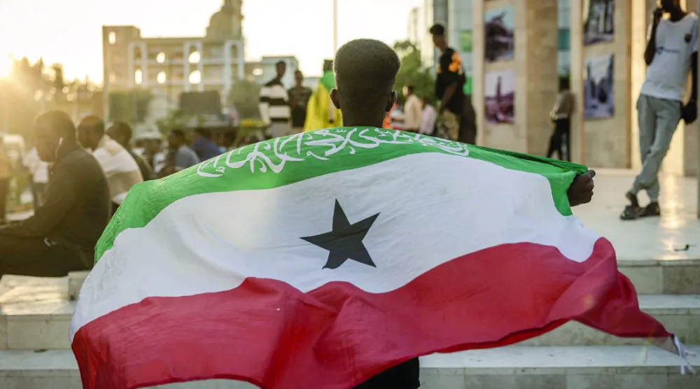 Man holding the Somaliland flag in front of the Hargeisa War memorial (AFP).