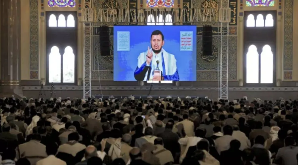 عناصر حوثيون يستمعون إلى زعيمهم عبد الملك الحوثي بقاعة في صنعاء عبر البث التلفزيوني (أ.ف.ب)