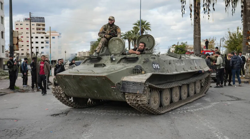 Syrian Security forces stand atop a military vehicle in the city of Latakia, Syria, 28 December 2025. (EPA)